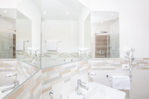 a bathroom with two sinks and a large mirror at Hotel Centrale in Lignano Sabbiadoro