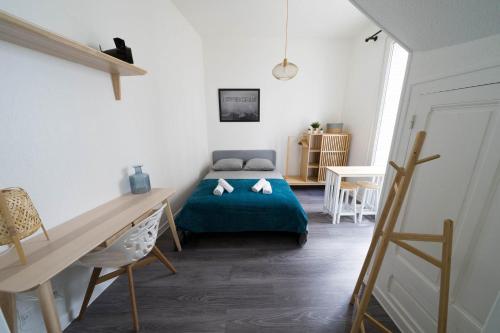 ein Schlafzimmer mit einem Bett und einem Schreibtisch in einem Zimmer in der Unterkunft AppartUnique - Chez Layette in Vichy