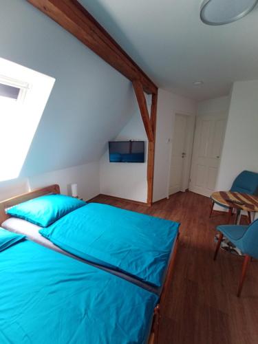 a bedroom with a blue bed and a table at Pension Zur Sülte in Sülte