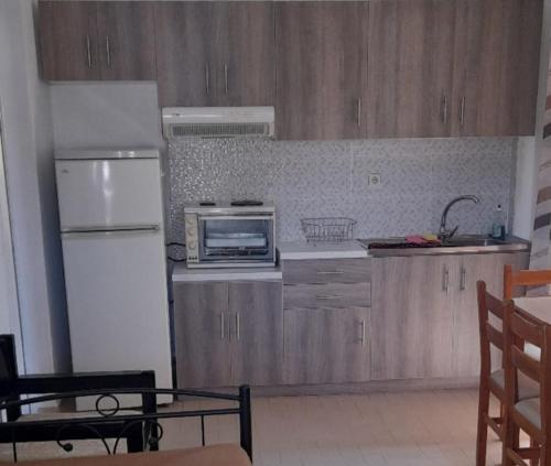 cocina con nevera blanca y microondas en Dimitris Apartments, en Balíon