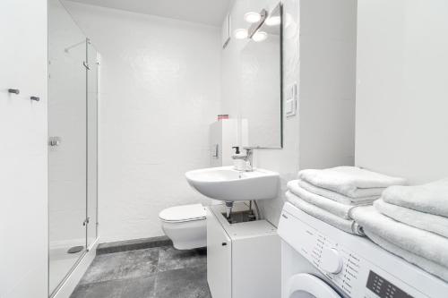 a white bathroom with a sink and a toilet at Apartament 400 bulwary Stare Miasto Apartamenty No 1 in Szczecin