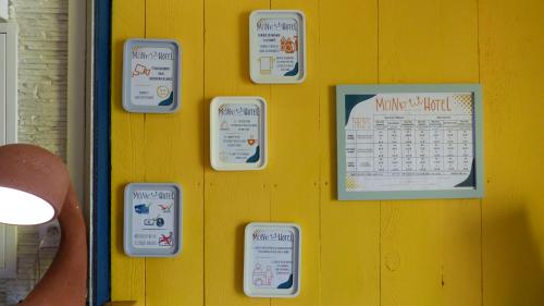 a wall with a calendar on a yellow wall at Mon P'tit Hôtel in Le Grau-dʼAgde