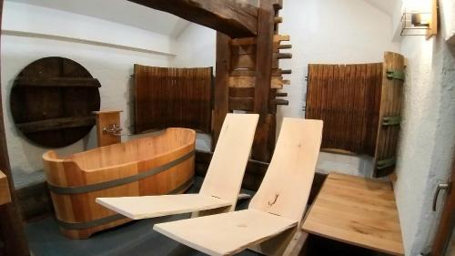 a room with two white chairs and a barrel at Haloze na dlani - Haloze in your hand, hiša s pogledom na hribe - a house vith a view of hills in Gruškovec
