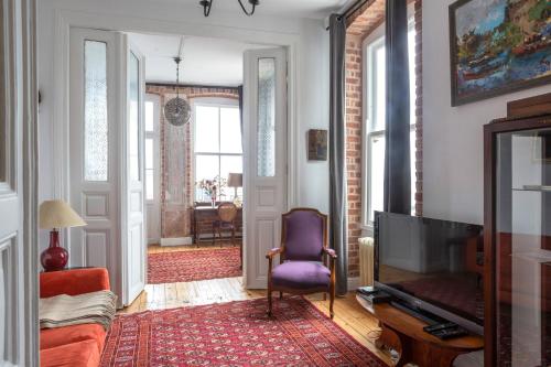 un salon avec une chaise violette et une télévision dans l'établissement A Historical Galata Flat w Bosphorus View, à Istanbul