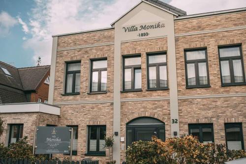 韋斯特蘭的住宿－Boutique Hotel Villa Monika，带有读写马里奥特的标志的砖砌建筑