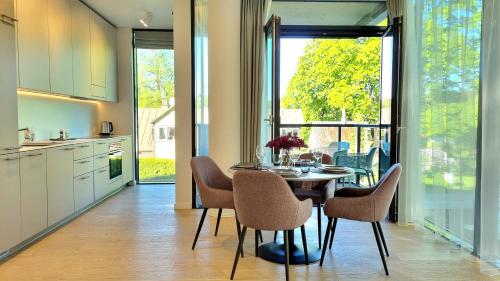 a kitchen and dining room with a table and chairs at Park Premium Apartments in Birštonas