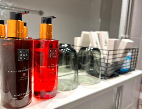 three bottles on a shelf in front of a mirror at Hotel Hospitz in Savonlinna