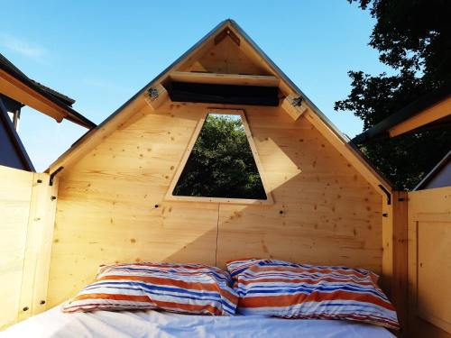a bed in a wooden cabin with a window at Starsbox Le Moline in Masserano