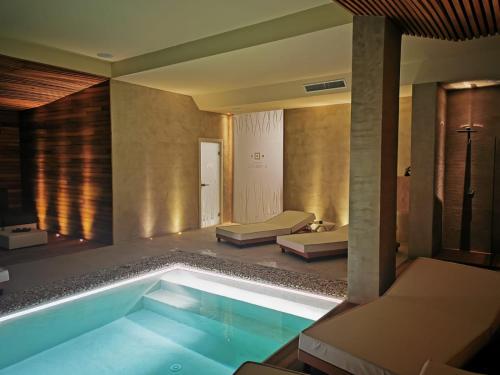 a swimming pool in a room with two beds at Resort Il Mulino in Favignana