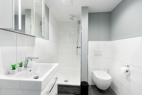 a white bathroom with a sink and a toilet at Apartment Gartenblick - 1 Zi, Küche, Duschbad, Terrasse sowie Gartenmitbenutzung in Bayreuth