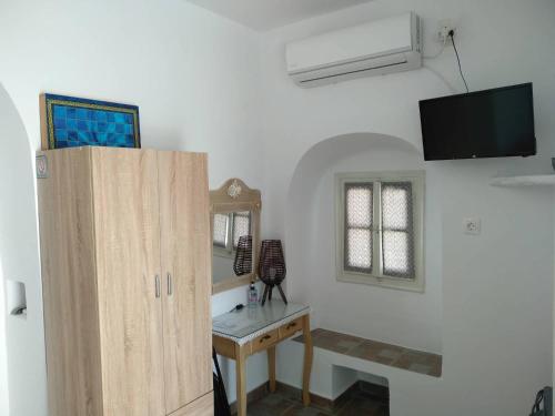 a room with a desk and a tv on a wall at Melissou place in Apollonia