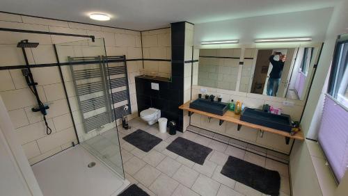 un hombre tomando una foto de un baño en Ferienhaus Am Oland, en Büsum