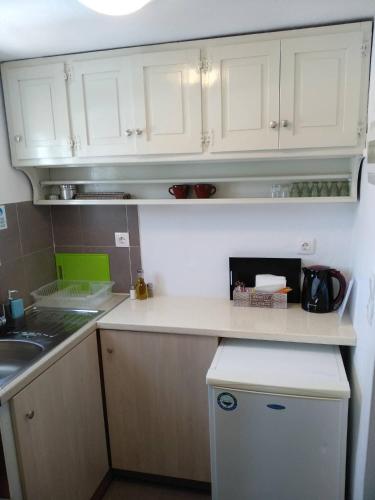 a kitchen with white cabinets and a counter top at Melissou place in Apollonia