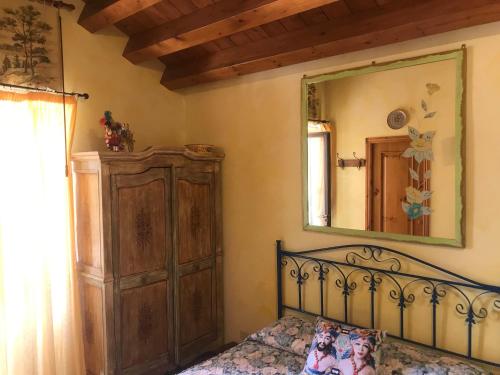a bedroom with a bed and a mirror on the wall at Il Giardino di Athena vista Valle dei Templi in Villaggio Peruzzo