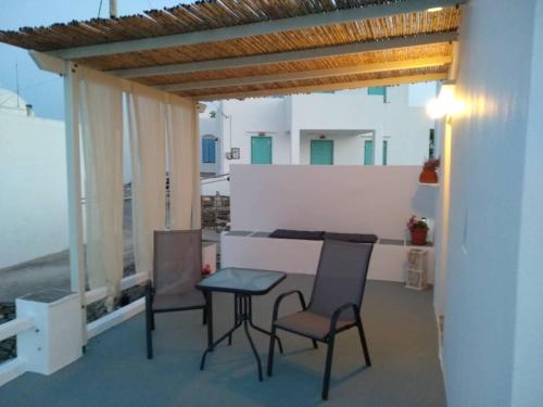 a patio with chairs and a table on a balcony at Melissou place in Apollonia