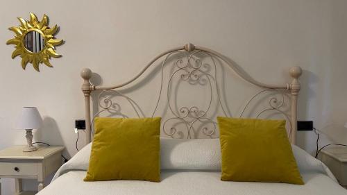 una camera con un letto bianco con due cuscini gialli di Podere Montese Country House a San Gimignano
