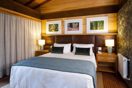 a bedroom with a large bed with two lamps at Hotel Toriba in Campos do Jordão
