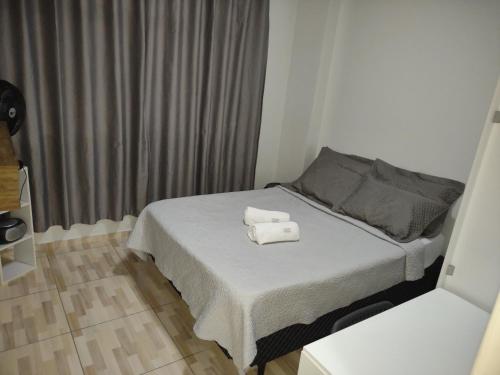 1 dormitorio con 1 cama con 2 toallas en Kitnet calma, en São José