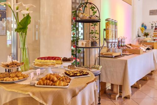 ein Buffet mit Gebäck und anderen Speisen auf dem Tisch in der Unterkunft Eco Hotel Ariston in Malcesine