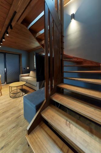 a staircase in a room with a couch and a table at Domki 1010 m in Ząb