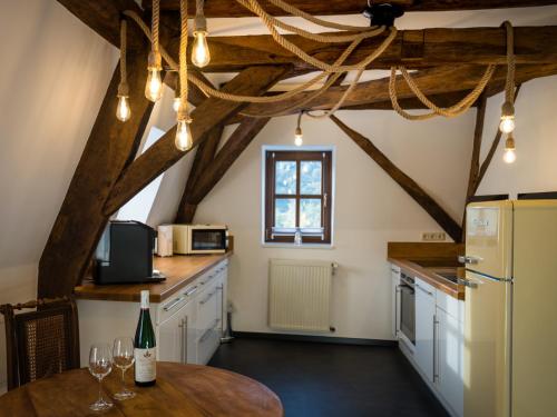 een keuken met witte kasten en een houten tafel bij Rißbacher Hof Mansarde anno 1737 in Traben-Trarbach