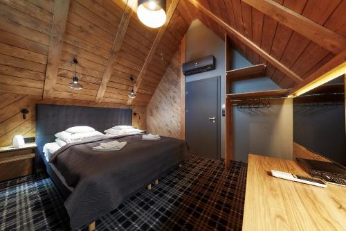 a bedroom with a bed in a room with wooden ceilings at Domki 1010 m in Ząb