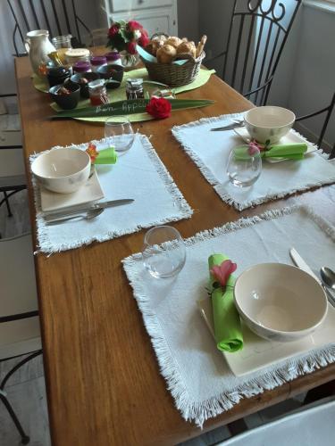 a wooden table with plates and glasses on it at La Tourterelle in Thaims