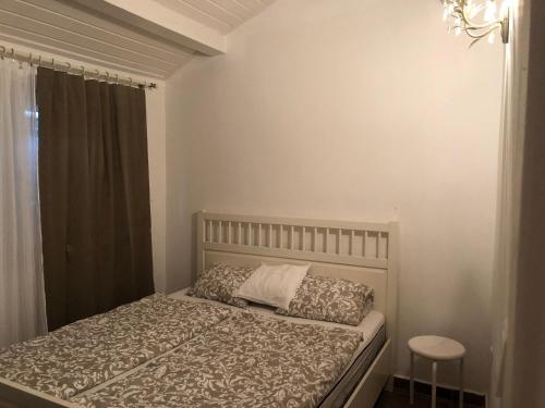 1 dormitorio con cama y ventana en Hortenzia Apartman, en Balatonföldvár