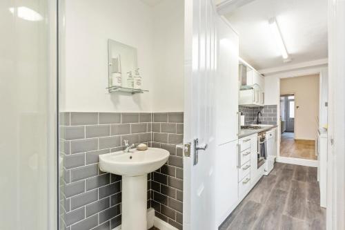 a white bathroom with a sink and a counter at Spacious & Central Entire Home in Nottingham