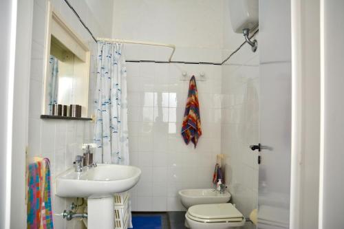 a white bathroom with a sink and a toilet at Casa Elisa in Porto Cesareo