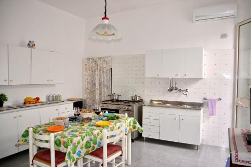 a kitchen with a table with chairs and a stove at Casa Elisa in Porto Cesareo