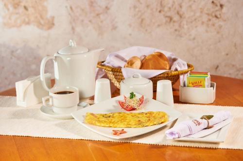 a table with a plate of food and a basket of bread at Hotel Los Tambos Boutique in Arequipa