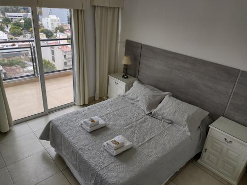 1 dormitorio con 1 cama grande y 2 toallas. en Altos del Boulevard en Santiago del Estero