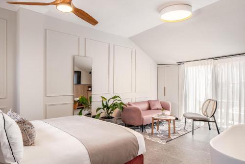 1 dormitorio con 1 cama grande y 1 silla rosa en Albi Boutique Hotel - Traveler's Choice 2024, en Jerusalén