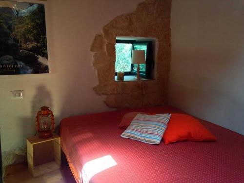 - une chambre avec un lit rouge et une fenêtre dans l'établissement Casa Giuliva, à Ferla