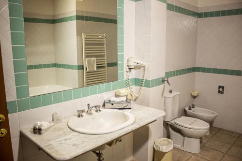 a bathroom with a sink and a toilet at Toscana Wellness Resort in Arcidosso