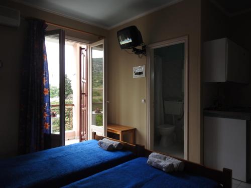 a bedroom with a large blue bed and a window at ChiosRoomsMaria in Armólia
