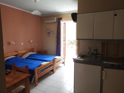 a bedroom with a bed and a kitchen with a sink at ChiosRoomsMaria in Armólia