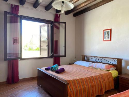 a bedroom with a bed and a large window at La casa di Andrea in Favignana