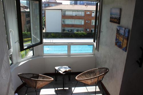 Habitación con 2 sillas y ventana en Apartamentos Zarautz Playa, con piscina y garaje, en Zarautz