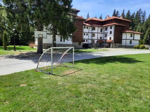 a basketball hoop in the grass in front of a building at Lusi Holiday, Смолянски езера in Smolyan