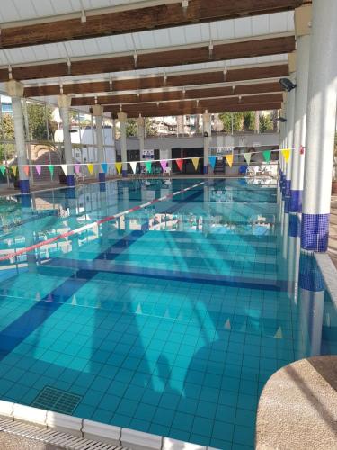 a large swimming pool with blue tiles on the floor at קיסריה נאות גולף- Oren Apartment in Caesarea