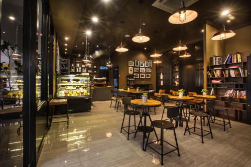 un restaurante con mesas y sillas y una librería en Manhattan Business Hotel Damansara Perdana, en Petaling Jaya