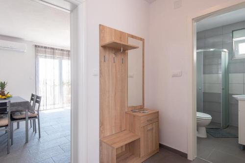 een badkamer met een toilet en een eetkamer met een tafel bij Apartman Harfa 1 in Orebić