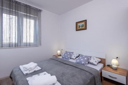 een kleine slaapkamer met een bed en een raam bij Apartman Harfa 1 in Orebić