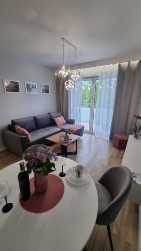 a living room with a white table and a couch at APARTAMENT De Lux Parkowa Olecko in Olecko