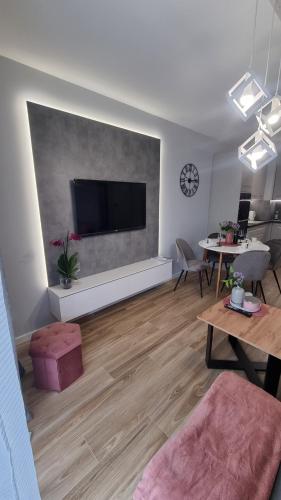 a living room with a flat screen tv on a wall at APARTAMENT De Lux Parkowa Olecko in Olecko