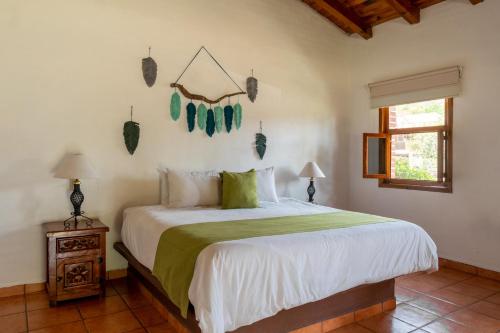 a bedroom with a bed with a green and white comforter at Las Jaras Aguas Termales in La Garita