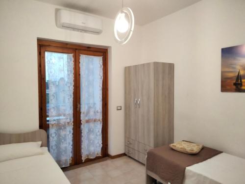 - une chambre avec un lit et une porte coulissante en verre dans l'établissement Villetta Clorinda, à San Nicola Arcella