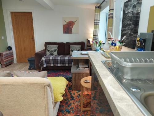 Bayview Lodge New Spacious Apartment في Breakish: غرفة معيشة مع حوض وأريكة